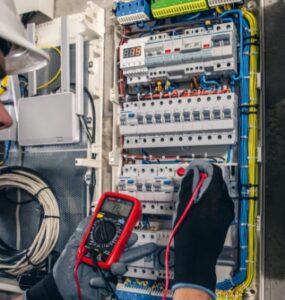 electrician inspecting and testing an electrical distribution panel